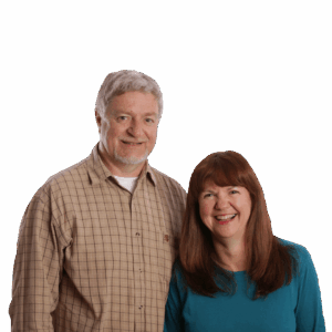 Russell & Jenny Fraser standing side by side, smiling in a portrait against a plain background