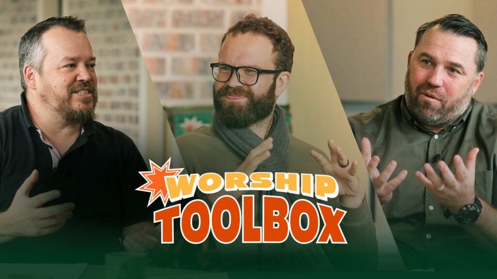 Three men in conversation around a table with a large 'Worship Toolbox' logo overlaid