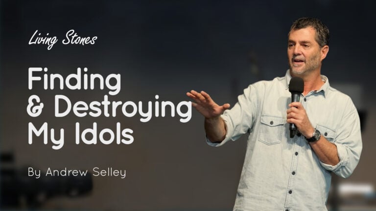 Andrew Selley speaking into a handheld microphone, with the title 'Finding & Destroying My Idols' displayed on the left