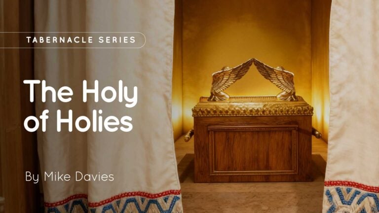 Curtains parted to reveal a wooden ark topped with two golden cherubim, lit by warm interior lighting