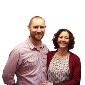 Two church leaders smiling and standing close together, shoulders touching