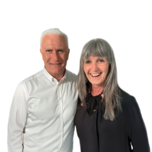 Portrait of Kim & Lorene Muller standing side by side, smiling on a plain background