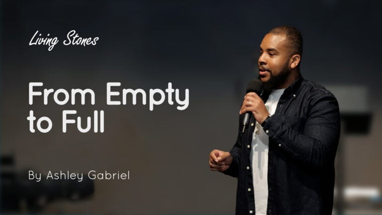 Ashley Gabriel speaking on stage holding a microphone with the title 'From Empty to Full' displayed beside him