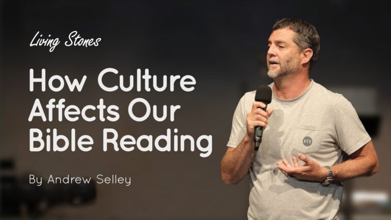 Andrew Selley speaking into a handheld microphone on stage with title text ‘How Culture Affects Our Bible Reading’