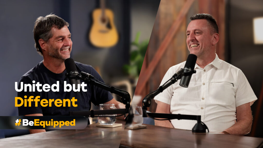 Andrew Selley (left) and Jonathan Stanfield (right) seated at a table speaking into microphones during a recorded