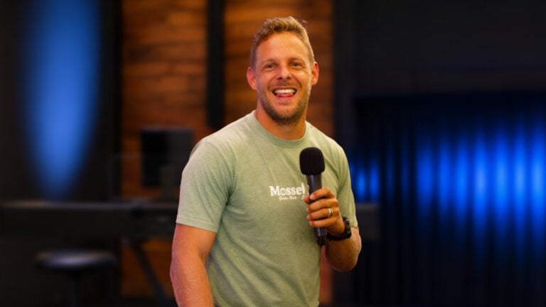 Hannes van den Heever smiling and holding a microphone on stage
