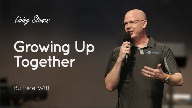 Male speaker Pete Witt holding a microphone and speaking on stage beside text 'Growing Up Together'