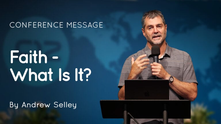 Speaker Andrew Selley at a lectern holding a microphone with slide reading ‘Faith - What Is It?’