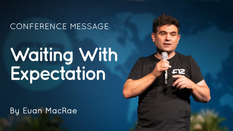 Speaker Euan MacRae on stage holding a microphone beside the words "Waiting With Expectation"