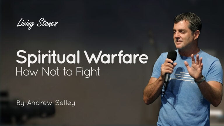 Speaker holding a microphone beside a slide titled “Spiritual Warfare: How Not to Fight”
